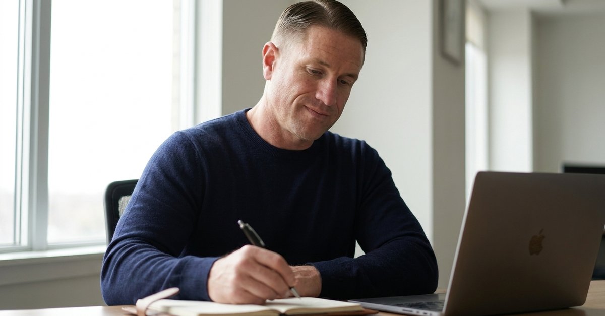 J. Michael writing in a notebook at his desk